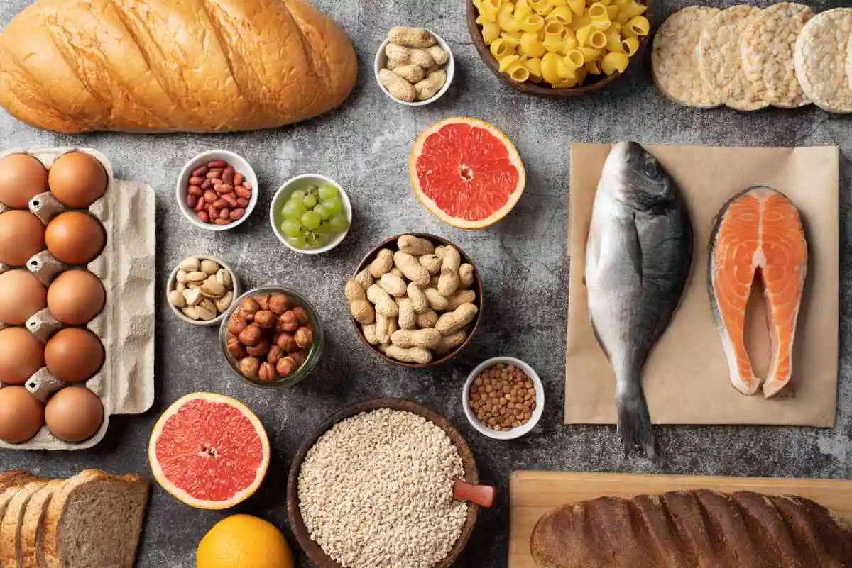 7 beneficios de la biotina: para qué sirve, fuentes naturales y cómo aprovecharla 1 Variedad de alimentos con biotina sobre una mesa: pescado, huevos, nueces, pan y frutas